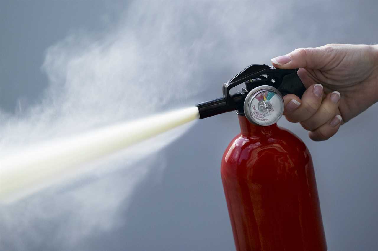 close up of person using fire extinguisher